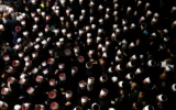 Des personnes entourant des religieux druzes syriens à leur arrivée au tombeau de Nabi Shuaib, dans le nord d'Israël, le 14 mars 2025 (Crédit : Jalaa Marey/AFP)