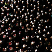 Des personnes entourant des religieux druzes syriens à leur arrivée au tombeau de Nabi Shuaib, dans le nord d'Israël, le 14 mars 2025 (Crédit : Jalaa Marey/AFP)