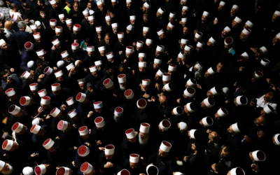 Des personnes entourant des religieux druzes syriens à leur arrivée au tombeau de Nabi Shuaib, dans le nord d'Israël, le 14 mars 2025 (Crédit : Jalaa Marey/AFP)