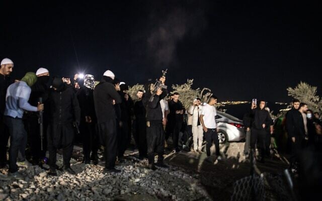 Un homme tirant en l'air avant l'arrivée de religieux druzes syriens au tombeau de Nabi Shuaib, dans le nord d'Israël, le 14 mars 2025. Rien n'indique que l'homme représenté ait blessé une femme. (Crédit : John Wessels/AFP)