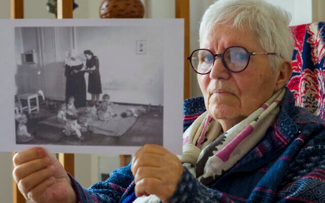 Gisèle Niango, née le 11 octobre 1943 dans une maternité "Lebensborn" en Belgique, l'une des nombreuses créées par le régime nazi allemand pour "l'expansion de la race aryenne", pose avec une photographie de son "Lebensborn" à Indersdorf, en Allemagne (Gisele est la 2e à droite sur la photo), lors d'une séance photo dans sa résidence pour personnes âgées à Nancy, dans le nord-est de la France, le 14 mars 2025. (Crédit : Jean-Christophe VERHAEGEN / AFP) Gisèle Niango, née le 11 octobre 1943 dans une maternité "Lebensborn" en Belgique, l'une des nombreuses créées par le régime nazi allemand pour "l'expansion de la race aryenne", pose avec une photographie de son "Lebensborn" à Indersdorf, en Allemagne (Gisele est la 2e à droite sur la photo), lors d'une séance photo dans sa résidence pour personnes âgées à Nancy, dans le nord-est de la France, le 14 mars 2025. (Crédit : Jean-Christophe VERHAEGEN / AFP)