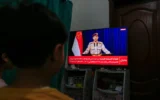 Déclaration télévisée du porte-parole militaire houthi Yahya Saree annonçant que le groupe rebelle a lancé une attaque contre un porte-avions américain en mer Rouge le 16 mars 2025. (Crédit : Mohammed HUWAIS / AFP)