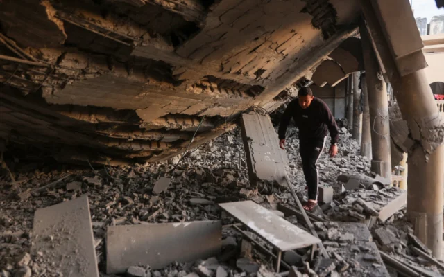 Un homme marche à travers les décombres d'une partie détruite d'une école transformée en camp à la suite d'une frappe israélienne dans la ville de Gaza le 18 mars 2025. (Crédit : Omar AL-QATTAA / AFP) Un homme marche à travers les décombres d'une partie détruite d'une école transformée en camp à la suite d'une frappe israélienne dans la ville de Gaza le 18 mars 2025. (Crédit : Omar AL-QATTAA / AFP)