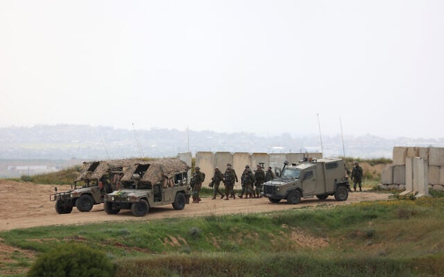 Des soldats de l'armée israélienne marchent le long de la frontière sud d'Israël avec le nord de la bande de Gaza, le 20 mars 2025. (Crédit : GIL COHEN-MAGEN / AFP)