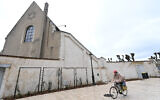 Une femme passe à vélo devant une synagogue d'Orléans, dans le centre de la France, le 23 mars 2025. (Crédit : JEAN-FRANCOIS MONIER / AFP)