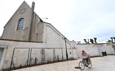 Une femme passe à vélo devant une synagogue d'Orléans, dans le centre de la France, le 23 mars 2025. (Crédit : JEAN-FRANCOIS MONIER / AFP)