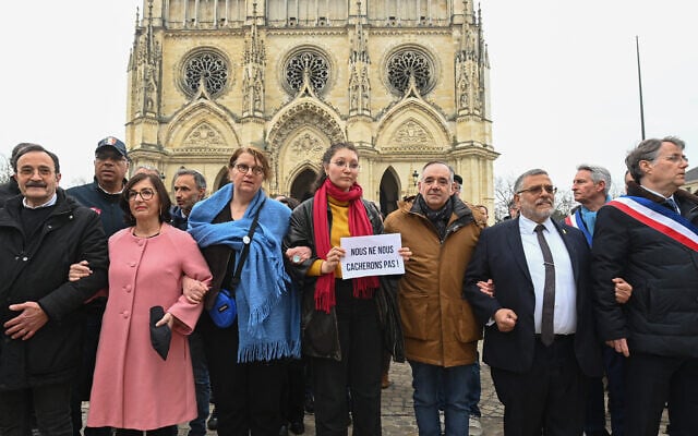 Le président de la communauté juive d'Orléans André Druon (à gauche), la préfète du Loiret Sophie Brocas (2e à gauche), le maire d'Orléans Serge Grouard (à droite) ainsi que des députés français et des manifestants participent à une marche silencieuse en soutien au rabbin d'Orléans, à Orléans, dans le centre de la France, le 25 mars 2025. (Crédit : Jean -François Monier/AFP) Le président de la communauté juive d'Orléans André Druon (à gauche), la préfète du Loiret Sophie Brocas (2e à gauche), le maire d'Orléans Serge Grouard (à droite) ainsi que des députés français et des manifestants participent à une marche silencieuse en soutien au rabbin d'Orléans, à Orléans, dans le centre de la France, le 25 mars 2025. (Crédit : Jean -François Monier/AFP)