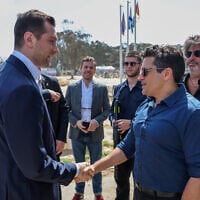 Le chef du Rassemblement national (RN) français, Jordan Bardella (à gauche), est accueilli par le ministre israélien des Affaires de la diaspora, Amichai Chikli, lors d'une visite au mémorial des victimes et des otages du pogrom de 2023 par des militants palestiniens, sur le site du festival de musique Supernova près du kibboutz Reim dans le sud d'Israël, le 26 mars 2025. (Crédit : Jack GUEZ / POOL / AFP)
