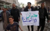 Un jeune Palestinien porte une banderole sur laquelle on peut lire en arabe « Le Hamas ne nous représente pas » lors d'une manifestation anti-Hamas et appelant à la fin de la guerre contre Israël, à Beit Lahiya, dans le nord de la bande de Gaza, le 26 mars 2025. (Crédit : AFP)