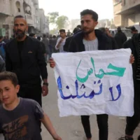 Un jeune Palestinien porte une banderole sur laquelle on peut lire en arabe « Le Hamas ne nous représente pas » lors d'une manifestation anti-Hamas et appelant à la fin de la guerre contre Israël, à Beit Lahiya, dans le nord de la bande de Gaza, le 26 mars 2025. (Crédit : AFP)