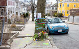 Des pancartes et des fleurs sont déposées sur un arbre près du lieu où les agents de l'ICE ont appréhendé Rumeysa Ozturk, étudiante diplômée de l'université Tuft, le 27 mars 2025 à Somerville, dans le Massachusetts. (Crédit : Scott Eisen / GETTY IMAGES NORTH AMERICA / Getty Images via AFP
