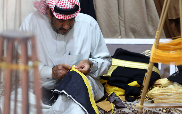Le tailleur saoudien Habib Mohammed ajoute une broderie sur un bisht, un long manteau orné tissé à la main qui a été pendant des siècles un symbole de statut social, porté par les rois et les princes, dans son atelier de la ville oasis de Hofuf, dans le gouvernorat d'Al-Ahsa en Arabie saoudite, le 16 février 2025. (Crédit Fayez Nureldine / AFP) Le tailleur saoudien Habib Mohammed ajoute une broderie sur un bisht, un long manteau orné tissé à la main qui a été pendant des siècles un symbole de statut social, porté par les rois et les princes, dans son atelier de la ville oasis de Hofuf, dans le gouvernorat d'Al-Ahsa en Arabie saoudite, le 16 février 2025. (Crédit Fayez Nureldine / AFP)