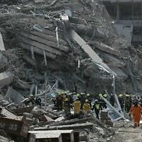 Des équipes de secours sur un chantier de construction où un bâtiment s'est effondré suite à un tremblement de terre en Birmanie, à Bangkok, en Thaïlande, le 28 mars 2025. (Crédit : Lillian Suwanrumpha/AFP)