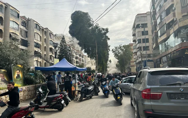 Des personnes se précipitent pour se mettre à l'abri alors que de la fumée s'élève du site d'une frappe israélienne dans le sud de Beyrouth, le 28 mars 2025. (Crédit : Anwar Amro/AFP) Des personnes se précipitent pour se mettre à l'abri alors que de la fumée s'élève du site d'une frappe israélienne dans le sud de Beyrouth, le 28 mars 2025. (Crédit : Anwar Amro/AFP)