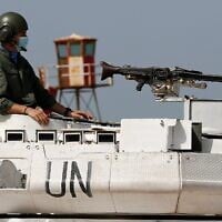 Un soldat de maintien de la paix de l'ONU assis sur un char sur une route qui mène à une base de la FINUL où se rencontrent les délégations libanaise et israélienne, dans la ville de Naqoura, au Liban, le 4 mai 2021. (Crédit : Hussein Malla/AP)