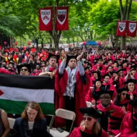 Des étudiants applaudissent à côté d'un drapeau palestinien lors de la cérémonie de remise des diplômes à Harvard Yard, à l'Université de Harvard, à Cambridge, Massachusetts, le 23 mai 2024. (Crédit : AP/Ben Curtis)