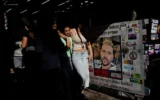 Des gens se promènent dans le marché du Carmel à Tel Aviv, le 27 septembre 2024, à côté du stand appartenant à Elkana Bohbot, kidnappée au festival Nova. (AP /Ohad Zwigenberg)