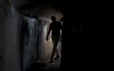 Un visiteur dans un tunnel du Hamas, dans la bande de Gaza, qui a été reconstitué sur la place des Otages à Tel Aviv, le 14 novembre 2024. (Crédit : AP Photo/Maya Alleruzzo)