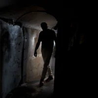 Un visiteur dans une reproduction de tunnel du Hamas, sur la Place des Otages, à Tel Aviv, le 14 novembre 2024. (Crédit : Maya Alleruzzo/AP)