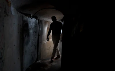 Un visiteur dans une reproduction de tunnel du Hamas, sur la Place des Otages, à Tel Aviv, le 14 novembre 2024. (Crédit : Maya Alleruzzo/AP)