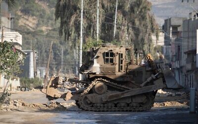 Des bulldozers militaires israéliens lors d'un raid militaire dans le camp de réfugiés de Nur Shams, près de la ville de Tulkarem en Cisjordanie, le 24 décembre 2024. (Crédit : Majdi Mohammed/AP)