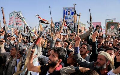 Des partisans houthis brandissant leurs mitrailleuses lors d'un rassemblement anti-Israël, à Sanaa, au Yémen, le 14 février 2025. (Crédit : Osamah Abdulrahman/AP)