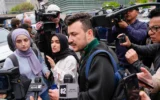 Des membres du groupe Apartheid Divest de l'université Columbia, dont Mahmoud Khalil, au centre, sont entourés par des membres des médias à l'extérieur du campus de l'université Columbia à New York, le 30 avril 2024. (Crédit : AP/Mary Altaffer)
