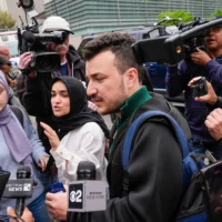 Des membres du groupe Apartheid Divest de l'université Columbia, dont Mahmoud Khalil, au centre, sont entourés par des membres des médias à l'extérieur du campus de l'université Columbia à New York, le 30 avril 2024. (Crédit : AP/Mary Altaffer)