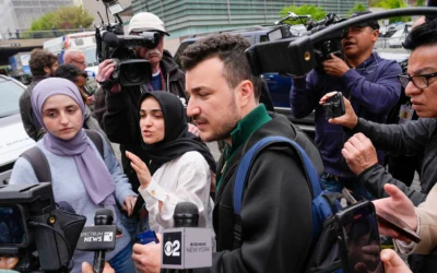 Des membres du groupe Apartheid Divest de l'université Columbia, dont Mahmoud Khalil, au centre, sont entourés par des membres des médias à l'extérieur du campus de l'université Columbia à New York, le 30 avril 2024. (Crédit : AP/Mary Altaffer)