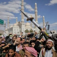 Des partisans houthis scandent des slogans lors d'un rassemblement anti-américain et anti-Israël à Sanaa, au Yémen, le 17 mars 2025. (Crédit : AP/Osamah Abdulrahman)