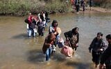 Des Syriens alaouites, qui ont fui les violences dans l'ouest de la Syrie, avancent dans les eaux de la rivière Nahr El Kabir, suite au massacre de masse des membres de la minorité alaouite, à Akkar, au Liban, le 11 mars 2025. (Reuters/Mohamed Azakir)