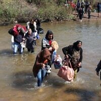 Des Syriens alaouites, qui ont fui les violences dans l'ouest de la Syrie, avancent dans les eaux de la rivière Nahr El Kabir, suite au massacre de masse des membres de la minorité alaouite, à Akkar, au Liban, le 11 mars 2025. (Reuters/Mohamed Azakir)