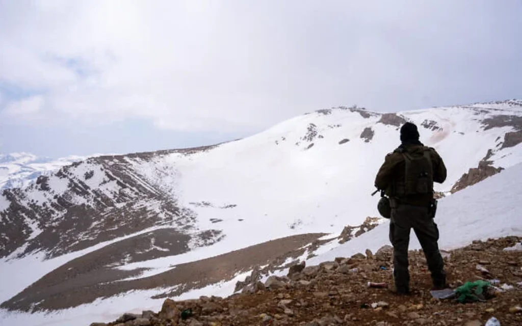 Un soldat de Tsahal se tient à côté d'un poste de l'armée israélienne dans la région du mont Hermon, dans le sud de la Syrie, le 11 mars 2025. (Emanuel Fabian/Times of Israel)