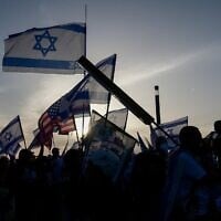 Des manifestants anti-gouvernementaux brandissent des drapeaux israéliens et américains devant un hôtel de Tel-Aviv accueillant les membres du 38e Congrès sioniste, le 22 avril 2023. (Crédit : Avshalom Sassoni/Flash90)