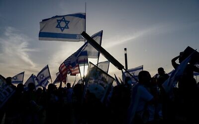 Des manifestants anti-gouvernementaux brandissent des drapeaux israéliens et américains devant un hôtel de Tel-Aviv accueillant les membres du 38e Congrès sioniste, le 22 avril 2023. (Crédit : Avshalom Sassoni/Flash90)