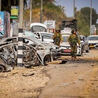 Des forces de sécurité à côté de voitures endommagées lors du pogrom perpétré par le Hamas le 7 octobre 2023, près de l'entrée du kibboutz Alumim, à la frontière entre Israël et Gaza, dans le sud d'Israël, le 9 octobre 2023. (Crédit : Yossi Zamir/Flash90)