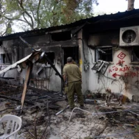 Des soldats évoluent au milieu des décombres laissés par les terroristes du Hamas dans le kibboutz Nir Oz, le 7 octobre 2023, dans le sud d'Israël, sur cette photo datée du 21 novembre 2023. (Chaim Goldberg/Flash90)