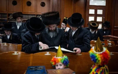 Des hommes et des enfants juifs ultra-orthodoxes lisant la Meguilat Estherr, qui raconte l'histoire de Pourim, à l'intérieur de la Yeshiva Belz (dynastie hassidique), à Jérusalem, le 24 mars 2024. (Crédit : Yonatan Sindel/Flash90)