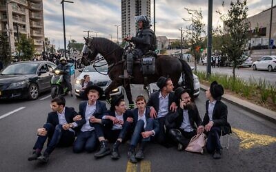 Des Juifs ultra-orthodoxes opposés au service militaire obligatoire se heurtent à la garde montée, à Jérusalem, le 28 janvier 2025. (Crédit : Chaïm Goldberg/Flash90)