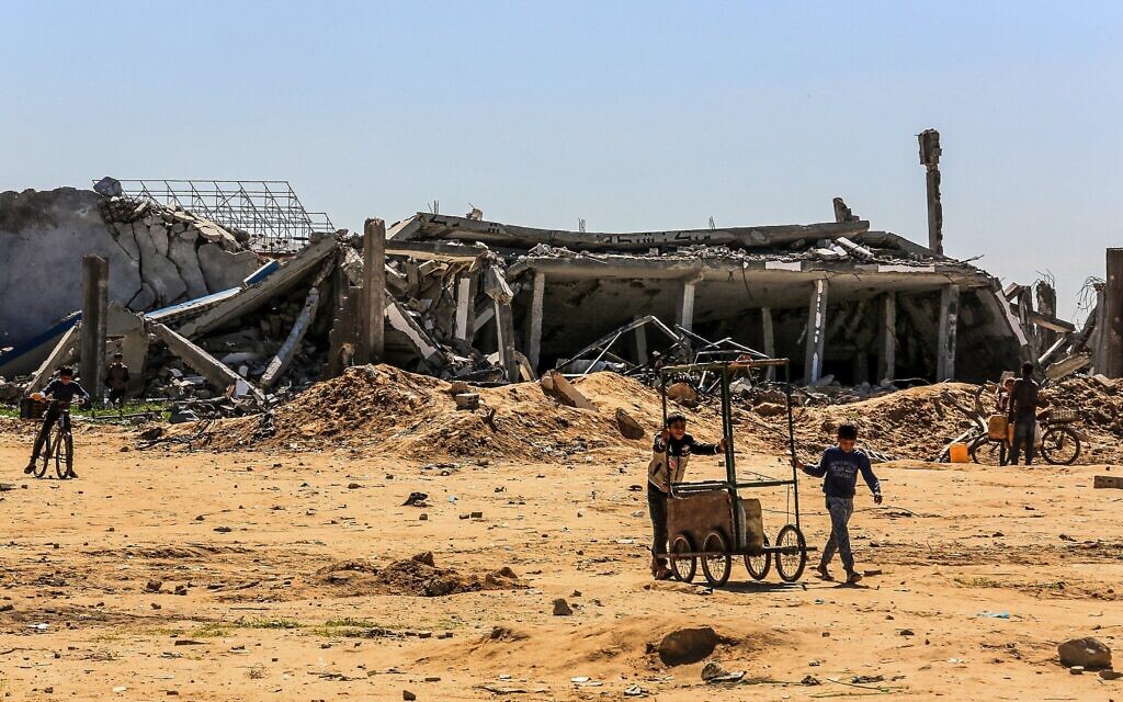 Des Palestiniens parmi les décombres de bâtiments sur une route près du passage de Kerem Shalom, à l'est de la ville de Rafah, dans le sud de la bande de Gaza, le 2 mars 2025.. (Crédit : Abed Rahim Khatib/Flash90)