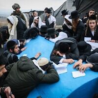 Des hommes ultra-orthodoxes priant sur la tombe du savant du 4e siècle Rav Ashi, située à la frontière israélo-libanaise, le 7 mars 2025. (Crédit : David Cohen/Flash90)