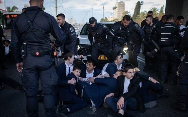 Des Juifs ultra-orthodoxes affrontent des policiers lors d'une manifestation illégale contre la conscription dans l'armée, sur la route 4 au niveau de Bnei Brak, le 19 mars 2025. (Erik Marmor/Flash90) Des Juifs ultra-orthodoxes affrontent des policiers lors d'une manifestation illégale contre la conscription dans l'armée, sur la route 4 au niveau de Bnei Brak, le 19 mars 2025. (Erik Marmor/Flash90)