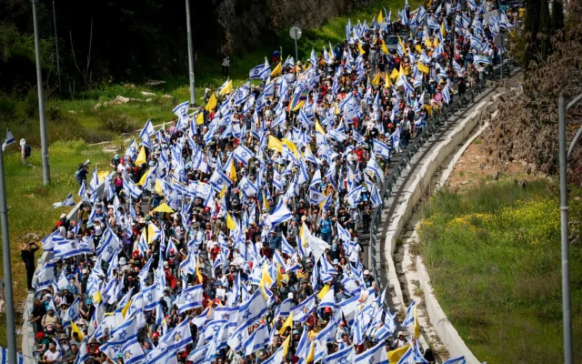 Des Israéliens participent à une marche de protestation contre la décision du Premier ministre israélien Benjamin Netanyahu de licencier le chef du Shin Bet Ronen Bar, sur la route numéro 1 près de Jérusalem, le 18 mars 2025. (Crédit : Yonatan SIndel/Flash90) Des Israéliens participent à une marche de protestation contre la décision du Premier ministre israélien Benjamin Netanyahu de licencier le chef du Shin Bet Ronen Bar, sur la route numéro 1 près de Jérusalem, le 18 mars 2025. (Crédit : Yonatan SIndel/Flash90)