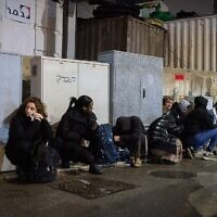 Des personnes se mettant à l'abri alors que les sirènes d'alerte annoncent l'arrivée d'un missile tiré depuis le Yémen, à Jérusalem, le 20 mars 2025. (Crédit : Chaïm Goldberg/Flash90)