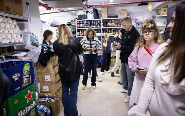 Des Israéliens se mettant à l'abri dans le sous-sol d'un supermarché alors que des sirènes d'alerte retentissent, à Tel Aviv, le 20 mars 2025. (Crédit : Miriam Alster/Flash90) Des Israéliens se mettant à l'abri dans le sous-sol d'un supermarché alors que des sirènes d'alerte retentissent, à Tel Aviv, le 20 mars 2025. (Crédit : Miriam Alster/Flash90)