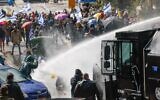 La police utilisant des canons à eau contre les protestataires lors des manifestations contre la décision du Premier ministre Benjamin Netanyahu de licencier le chef du Shin Bet, Ronen Bar, à Jérusalem, le 20 mars 2025. (Crédit : Yonatan Sindel/Flash90)