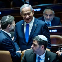 Le Premier ministre Benjamin Netanyahu, à droite, et le ministre des Finances Bezalel Smotrich en séance plénière de la Knesset avant le vote final sur le budget de l'État 2025, le 25 mars 2025. (Crédit : Yonatan Sindel/Flash90)