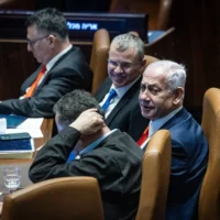Le Premier ministre Benjamin Netanyahu, le ministre de la Justice Yariv Levin et d'autres ministres dans le plénum de la Knesset lors d'un vote sur une loi visant à réformer le processus de sélection des juges israéliens, le 27 mars 2025. (Crédit : Chaïm Goldberg/Flash90)
