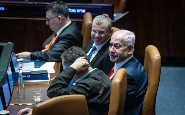 Le Premier ministre Benjamin Netanyahu, le ministre de la Justice Yariv Levin et d'autres ministres dans le plénum de la Knesset lors d'un vote sur une loi visant à réformer le processus de sélection des juges israéliens, le 27 mars 2025. (Crédit : Chaïm Goldberg/Flash90)