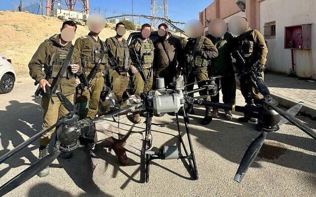Des soldats israéliens se tiennent devant un drone utilisé dans une tentative de trafic de drogue à la frontière égyptienne, le 25 mars 2025. (Crédit : Armée israélienne) Des soldats israéliens se tiennent devant un drone utilisé dans une tentative de trafic de drogue à la frontière égyptienne, le 25 mars 2025. (Crédit : Armée israélienne)